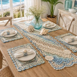 May include: A wooden dining table set with a coastal theme. The table is set with crocheted placemats and a runner in shades of blue and cream. Each place setting includes a white plate, napkin, and seashell napkin ring. Seashells and a vase of flowers decorate the table.