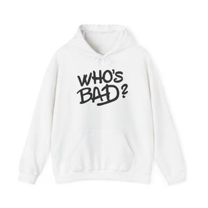 Puede incluir: Sudadera con capucha blanca con el texto "WHO'S BAD?" en letras negras y en negrita. La sudadera tiene un bolsillo delantero y una capucha con cordón. Una prenda informal y cómoda.