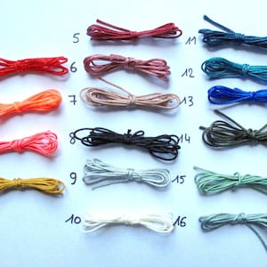 Pode incluir: Uma cole&ccedil;&atilde;o de 16 cord&otilde;es de diferentes cores, cada um amarrado em um n&oacute;. Os cord&otilde;es s&atilde;o numerados de 1 a 16.
