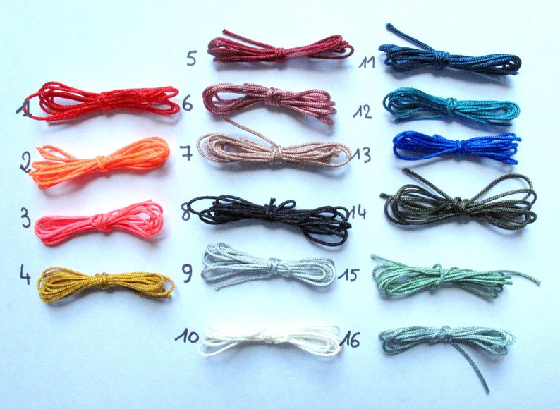Pode incluir: Uma cole&ccedil;&atilde;o de 16 cord&otilde;es de diferentes cores, cada um amarrado em um n&oacute;. Os cord&otilde;es s&atilde;o numerados de 1 a 16.