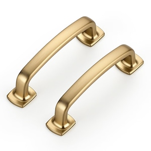 May include: Two matching cabinet pulls with a brushed gold finish. Each handle features a smooth, arched bar design with rectangular mounting bases at both ends, providing a clean and uniform look for furniture or cabinetry hardware applications.