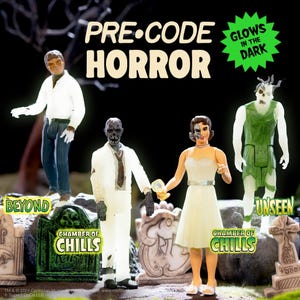 May include: Four horror-themed action figures stand before miniature tombstones. The figures include a werewolf, a zombie in a white suit, a woman with a half-skull face, and a green swamp creature. Text reads PRE-CODE HORROR, GLOWS IN THE DARK, BEYOND, CHAMBER OF CHILLS, and UNSEEN.