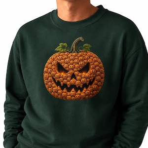 May include: A dark forest green crewneck sweatshirt featuring a large graphic of a single pumpkin composed of many smaller, orange jack-o'-lanterns. The central pumpkin has a glowing, menacing face with sharp, jagged eyes and a wide, toothy grin.