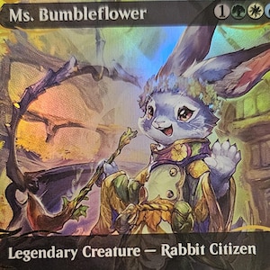 Op de afbeelding: Een holografische Magic: The Gathering ruilkaart met Ms. Bumbleflower, een konijn-burger personage. De kaart bevat de tekst Ms. Bumbleflower, Legendary Creature - Rabbit Citizen en spelregels, tegen een kleurrijke, geïllustreerde achtergrond.