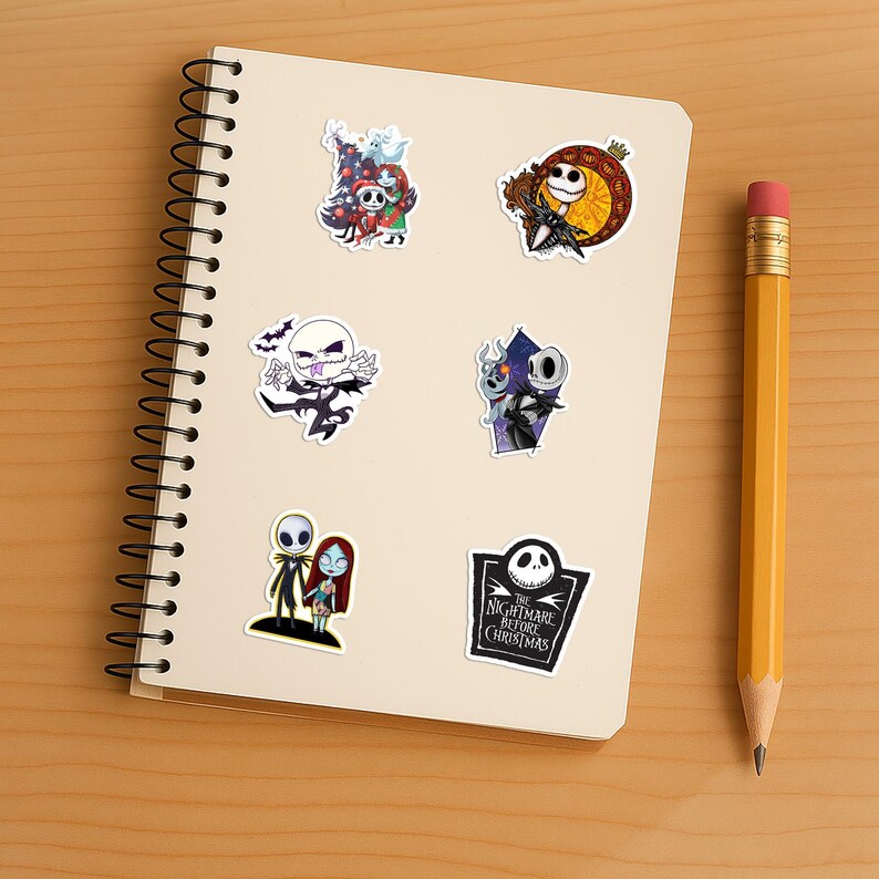 May include: A spiral-bound notebook featuring six stickers of characters from The Nightmare Before Christmas, including Jack Skellington and Sally in various poses, alongside a yellow pencil with a pink eraser resting on the side.