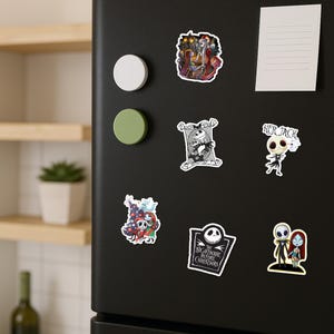 May include: A collection of six vinyl stickers featuring characters from The Nightmare Before Christmas, including Jack Skellington and Sally in various scenes, a tombstone logo, and the text Her Jack, displayed on a black refrigerator door.
