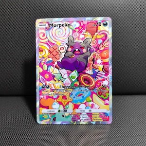 May include: A Morpeko trading card with 70 HP, featuring a purple and black character surrounded by colorful candy, chocolate, and donuts. The card displays the Energizer Wheel attack text, a weakness of +20, and a retreat cost symbol.