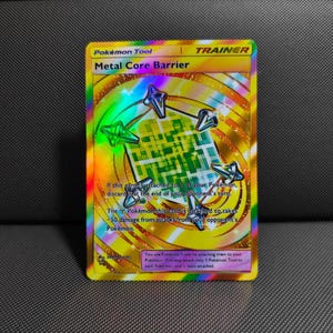 May include: A holographic Metal Core Barrier Pokémon Trainer card featuring a central green grid pattern surrounded by metallic spikes. The card text explains that the attached Pokémon takes 50 less damage from attacks during the opponent's turn.