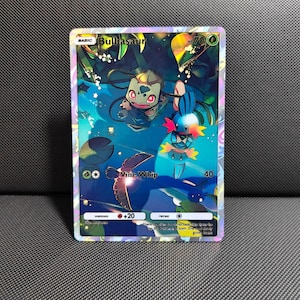May include: A holographic Bulbasaur trading card featuring a full-art illustration of the character in a pond setting with a Mudkip. The card displays 70 HP, the Vine Whip attack with 40 damage, a fire weakness, and a colorless retreat cost.
