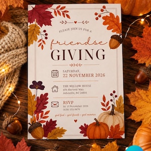 May include: A rectangular invitation card for a Friendsgiving event featuring autumn-themed illustrations of colorful maple leaves, acorns, and pumpkins. The text reads: Please join us for a Friendsgiving, Saturday, 22 November 2026, The Willow House, 456 Harvest Way, Asheville, NC 28801, RSVP by 15 November 2026, (828) 555-9876, good food, good friends, good memories.