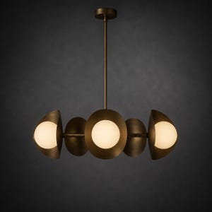 May include: A bronze-toned chandelier featuring a central vertical rod and a horizontal bar supporting five circular, bowl-shaped metal shades. Three of these shades contain glowing, spherical white glass bulbs, creating a balanced light fixture.