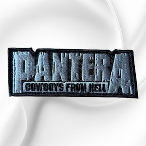 May include: A rectangular embroidered patch featuring the word PANTERA in large, light gray, distressed-style lettering. Below the main text, the words COWBOYS FROM HELL are embroidered in a smaller, white, sans-serif font on a black background.