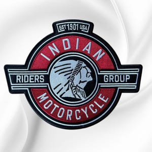May include: A circular embroidered patch featuring a red and black design with a white profile of a Native American figure. The text reads INDIAN MOTORCYCLE RIDERS GROUP and EST 1901 USA in white lettering. The patch has a black border and white accents.