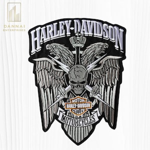 May include: A black and silver embroidered patch featuring the text HARLEY-DAVIDSON at the top and MOTORCYCLES at the bottom. The design includes a central skull, two eagle heads, wings, lightning bolts, and a small Harley-Davidson Motor Cycles logo.