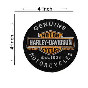May include: A circular black embroidered patch featuring the Harley-Davidson logo in orange, white, and black. The text reads Genuine Motor Harley-Davidson Cycles Trade Mark Est. 1903 Motorcycles. The patch measures 4 inches by 4 inches.
