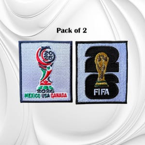 May include: A pack of 2 embroidered patches featuring the 2026 FIFA World Cup branding. One patch displays the tournament logo with the text 2026 MEXICO USA CANADA. The second patch features a large black 26 with a gold trophy and FIFA text.