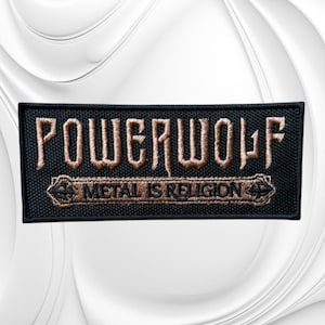 May include: A rectangular black embroidered patch featuring the word POWERWOLF in large, stylized tan lettering. Below the band name, a smaller tan banner contains the text METAL IS RELIGION, flanked by small cross symbols on each side.