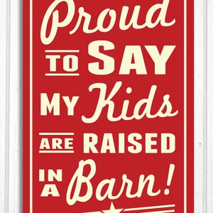 Può includere: Un cartello rettangolare rosso con la scritta "Proud to Say My Kids Are Raised In A Barn!" in un carattere color crema in stile vintage. Una stella bianca in basso. Il cartello è incorniciato in bianco.