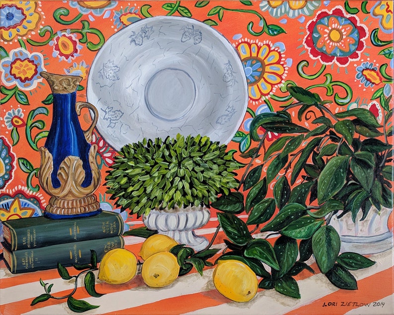 Puede incluir: Una pintura de bodeg&oacute;n con una jarra azul y dorada, un plato blanco, un arbusto verde en una maceta blanca y limones sobre un mantel a rayas rojas y blancas con un patr&oacute;n floral.