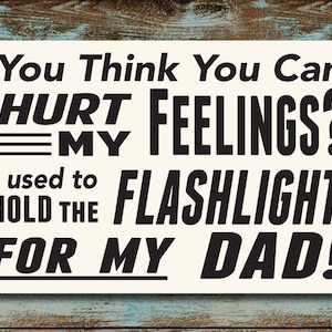 May include: Black and white text on a white background. The text reads: "You Think You Can Hurt My Feelings? I used to hold the flashlight for my dad!"