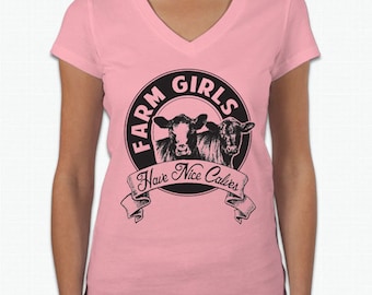 May include: Pink V-neck t-shirt with a black circle graphic featuring two cows and the text "Farm Girls Have Nice Calves".