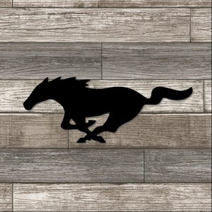 May include: A black silhouette of a running horse against a wood-grain background. The horse is depicted in full stride, with its legs extended and its tail flowing. The background features horizontal planks in shades of gray and brown.