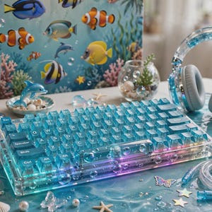 May include: A mechanical keyboard with translucent blue keycaps and a clear acrylic frame featuring bubble accents. The setup includes matching blue headphones, a digital pet device, a glass of water, and a desk mat with an underwater fish theme.