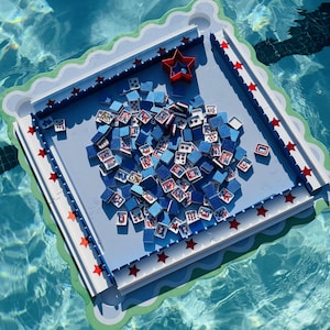 May include: A square floating game board with a light blue surface and a scalloped green border. The board features a red star-shaped container and numerous small blue tiles with patriotic red, white, and blue graphic designs scattered across.