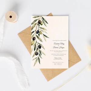 May include: A rectangular wedding invitation card featuring a watercolor illustration of an olive branch with green leaves and dark olives on the left side, with black printed text on a cream background, placed on a brown paper envelope.