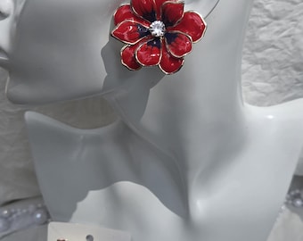 Red and black enamel flower earrings featuring a central crystal detail.