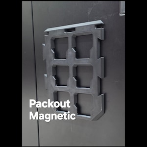 Può includere: Un organizer magnetico nero dotato di una griglia con sei aperture rettangolari per il montaggio di utensili. L'oggetto è fissato su una superficie nera piana e riporta la scritta bianca Packout Magnetic sul lato inferiore sinistro.