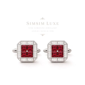 Puede incluir: Un par de gemelos plateados con un centro cuadrado de cuatro piedras preciosas de color rojo intenso, rodeado por un borde de piedras claras en talla baguette. El texto SIMSIM LUXE FINE GEMSTONE JEWELLERY JAIPUR ESTD IN 1990 aparece sobre ellos.