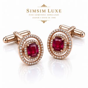 Puede incluir: Un par de gemelos de oro rosa con un rubí rojo central de talla cojín rodeado por dos halos concéntricos de pequeños diamantes blancos. El texto SIMSIM LUXE FINE GEMSTONE JEWELLERY JAIPUR ESTD IN 1990 aparece sobre las piezas.