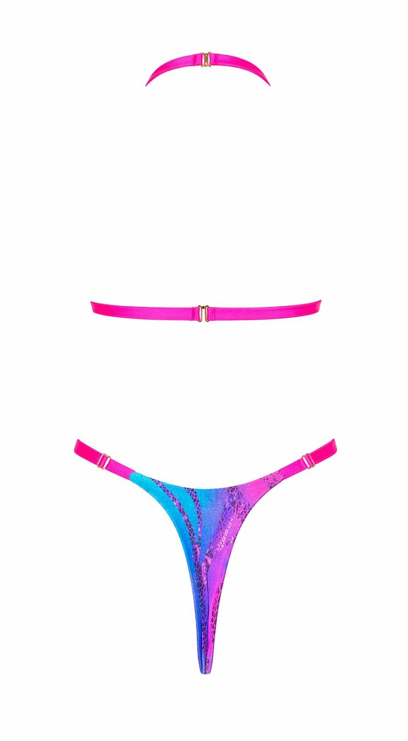 May include: A two-piece lingerie set featuring a bright hot pink halter neck strap and a matching horizontal back strap with gold-tone hardware. The thong-style bottom features a vibrant blue and purple gradient pattern with a dark snakeskin print.