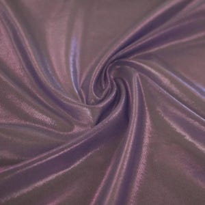 May include: A piece of fabric in a deep shade of lavender purple with a smooth, reflective, and metallic sheen. The material is draped in soft, flowing folds that create varying light and shadow patterns across the surface of the textile.