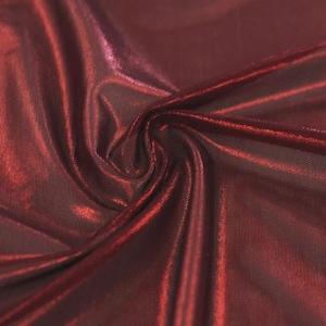 May include: A deep burgundy fabric with a metallic, reflective sheen. The material features a fine, mesh-like texture visible beneath the glossy surface, with soft folds and drapes creating varied light and shadow across the dark red surface.