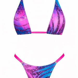 May include: A two-piece bikini set featuring a vibrant pink and blue tie-dye pattern with a dark snakeskin print overlay. The top has triangle cups with bright pink adjustable straps, and the bottom is a high-cut style with pink side straps.
