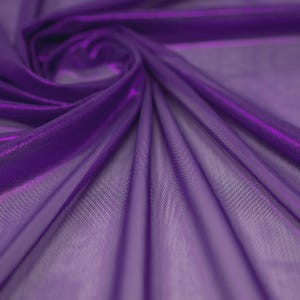 May include: A sheer, deep purple fabric with a fine mesh texture. The material is draped in soft, flowing folds that create a swirling pattern, highlighting the translucent quality and the vibrant, saturated violet hue of the textile surface.
