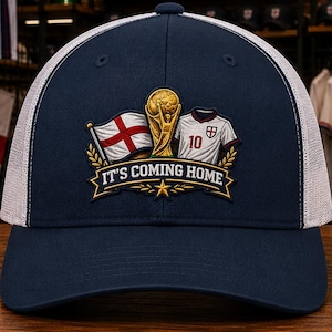 May include: A navy blue and white trucker hat featuring an embroidered patch on the front. The patch displays a gold trophy, an England flag, and a white soccer jersey with the number 10, above the text IT'S COMING HOME on a gold banner.
