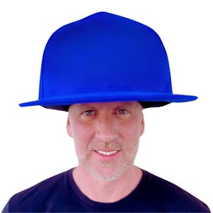 May include: A vibrant blue hat with a wide brim and a rounded crown. The hat is a solid, bright blue color and appears to be made of a smooth fabric. The hat is worn by a person.