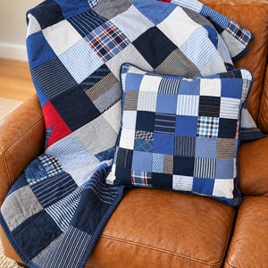 May include: A patchwork quilt and a matching square throw pillow constructed from various blue, white, and red fabric squares. The quilt features a mix of solid colors, stripes, and plaid patterns, while the pillow displays a similar grid design.