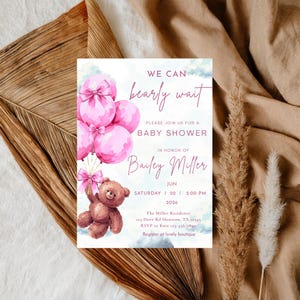 May include: Baby shower invitation featuring pink balloons and a teddy bear. The invitation reads "We can bearly wait" and includes details for the event, such as the date, time, and location, in honor of Bailey Miller.
