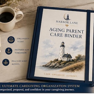 May include: A navy blue "Aging Parent Care Binder" with a lighthouse illustration, a gold pen, and a coffee cup. The binder has the text "Harbor Lane" and "Care, Organize, Support." The binder is on a wooden surface.