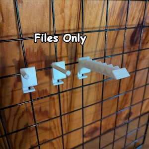 May include: Three white 3D printed plastic hooks and a display rack attached to a black wire grid panel. The white components include two single peg hooks and one tiered display arm. The text "Files Only" is visible in white font.