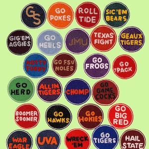 May include: A collection of beaded buttons with team names and phrases like "Go Pokes" and "Roll Tide" in various colors. The text "Game Day Beaded Buttons" and "Find Your Team!" are at the top and bottom.
