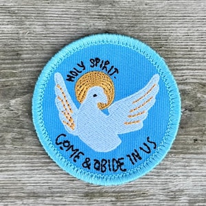 May include: A blue embroidered patch with a white dove and a yellow halo. The text "HOLY SPIRIT COME & ABIDE IN US" is embroidered around the dove.