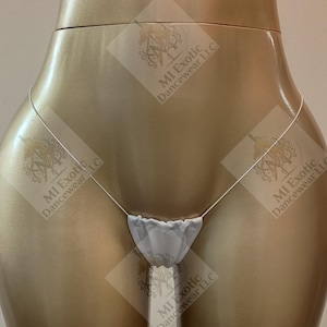 May include: A white thong with thin side straps, featuring a small, gathered fabric front panel. The garment is displayed on a gold-toned mannequin torso, with the text MI Exotic Dancewear LLC overlaid multiple times across the image.