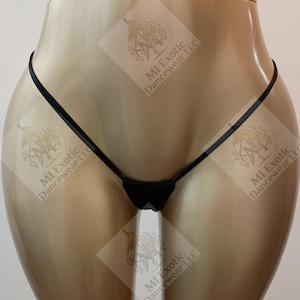May include: A black thong featuring a minimalist design with thin side straps and a small triangular front panel. The garment is displayed on a mannequin, with the text MI Exotic Dancewear LLC visible as a watermark across the image.