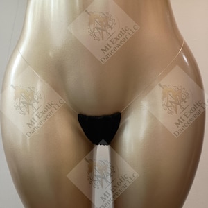 May include: A black thong with a minimal fabric front panel and a thin, clear plastic strap. The garment is displayed on a smooth, gold-toned mannequin torso. The text MI Exotic Dancewear LLC is visible in a watermark pattern across the image.