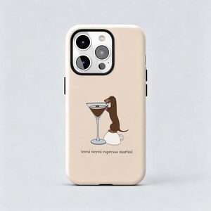 以下が含まれることがあります： ベージュのスマートフォンケース。白いコーヒーカップの上に立ち、ダークな液体が入ったマティーニグラスに手を伸ばす茶色のダックスフントが描かれています。イラストの下には「teeni weeni espresso martini」という文字が黒色でプリントされています。